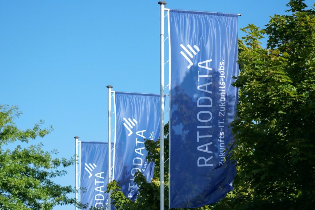 Drei blaue Fahnen mit Ratiodata Logo.