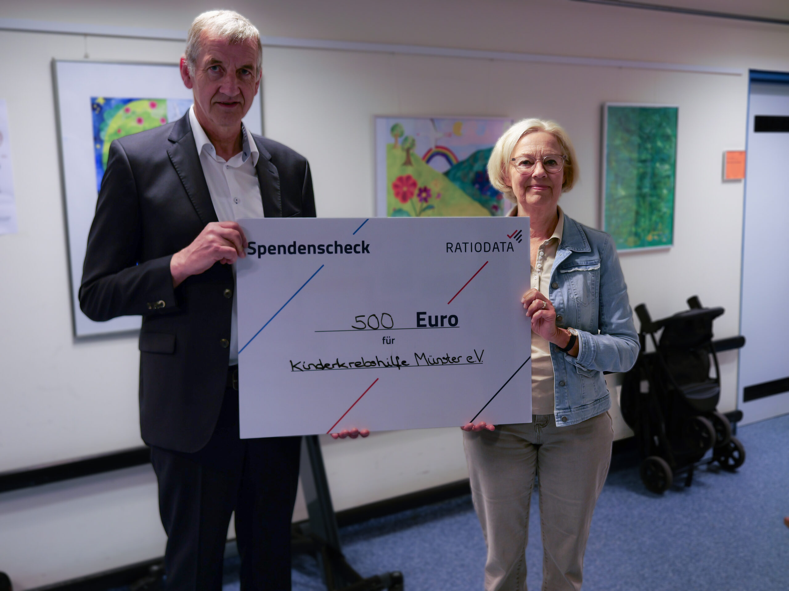 Christoph Lohaus (Ratiodata) und Anette Blomberg (stellvertretende Vorsitzende der Kinderkrebshilfe Münster e. V.) bei der symbolischen Scheckübergabe