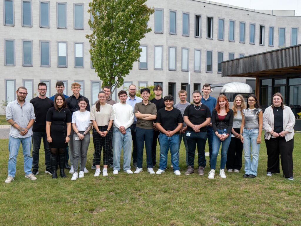 Die 21 neuen Auszubildende 2025 vor einem der Gebäude am Standort Münster