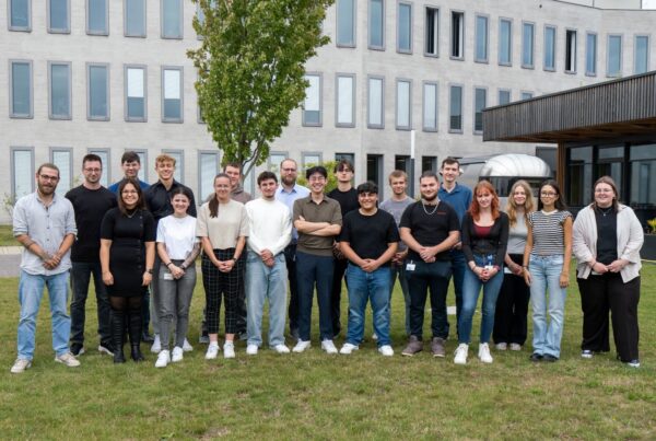 Die 21 neuen Auszubildende 2025 vor einem der Gebäude am Standort Münster